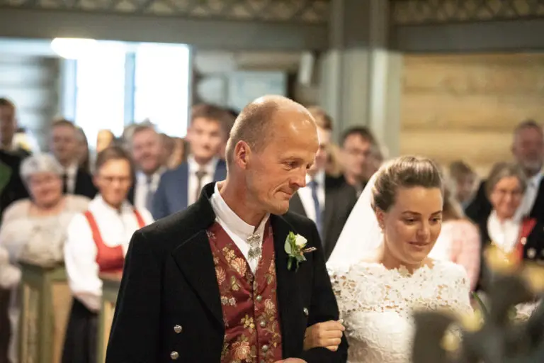 Bruden følges opp kirkegulvet av sin far