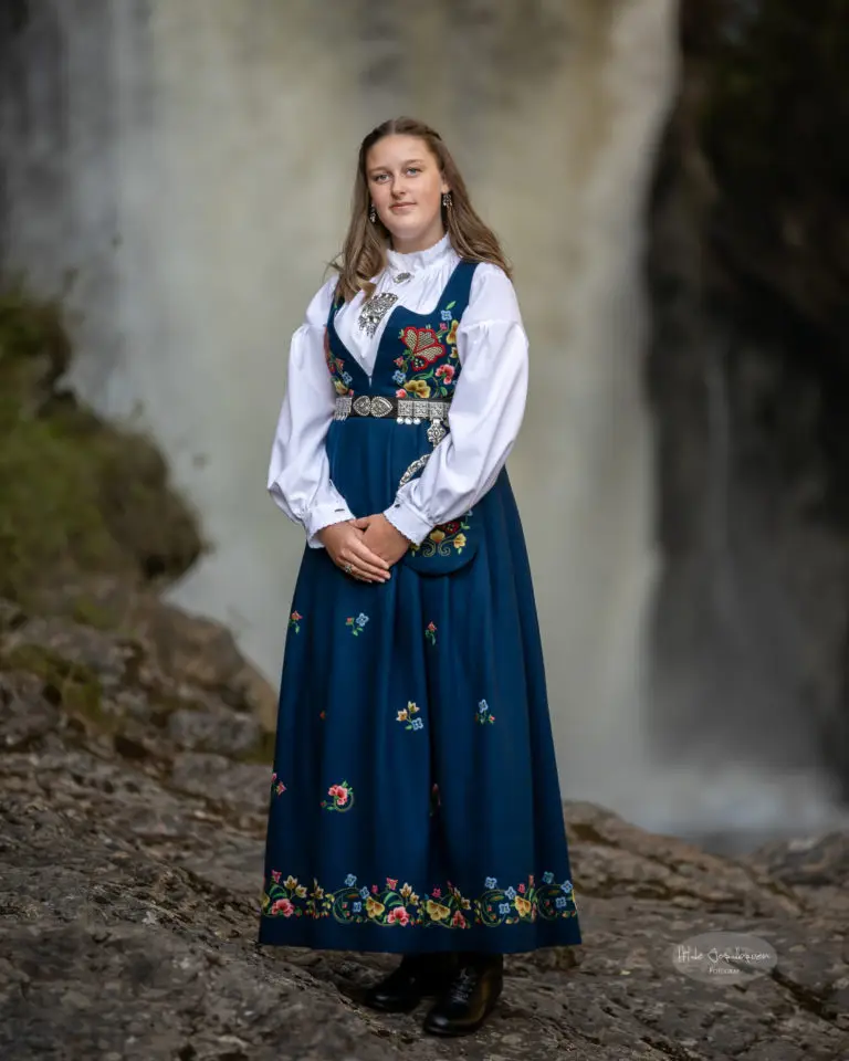 Flotte Maren foran fossen. Bunaden hennes er den blå versjonen av Gudbrandsdals Festdrakt.